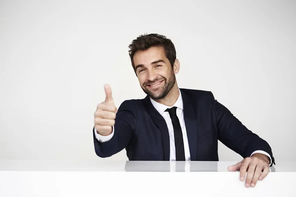Lächelnder Geschäftsmann mit erhobenem Daumen — Stockfoto