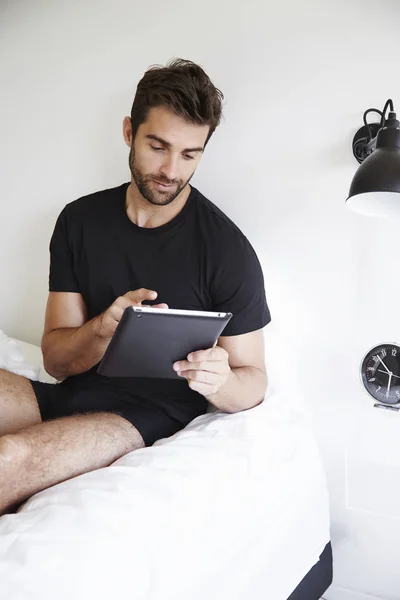 Uomo che utilizza tablet digitale a letto — Foto Stock