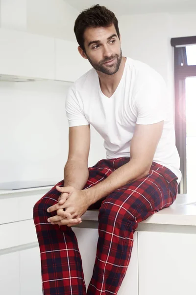 Hombre en pijama sentado en la cocina — Foto de Stock