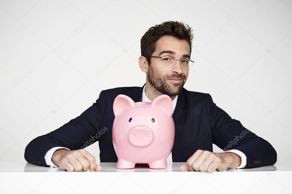 Smiling businessman with piggybank 