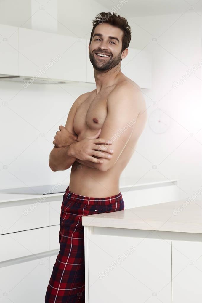 Shirtless man in kitchen