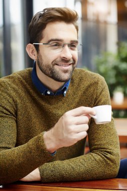 Kahve fincanı tutan adam.