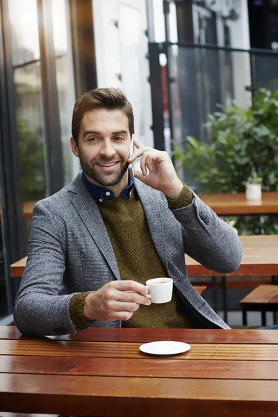 Homem com xícara de café fazendo uma chamada — Fotografia de Stock
