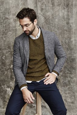 Taburede oturan ciddi adam