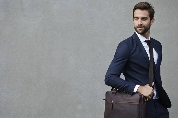 Бизнесмен в костюме держит портфель — стоковое фото