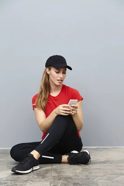Sportieve vrouw texting op smartphone — Stockfoto
