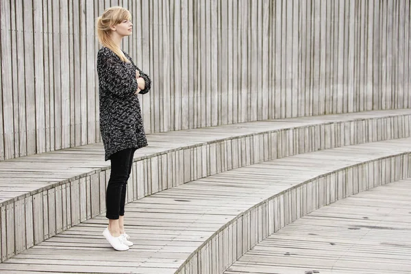 Woman standing on wooden steps — Stock Photo, Image