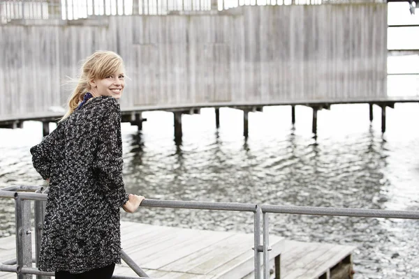 Junge Frau steht auf Seebrücke — Stockfoto