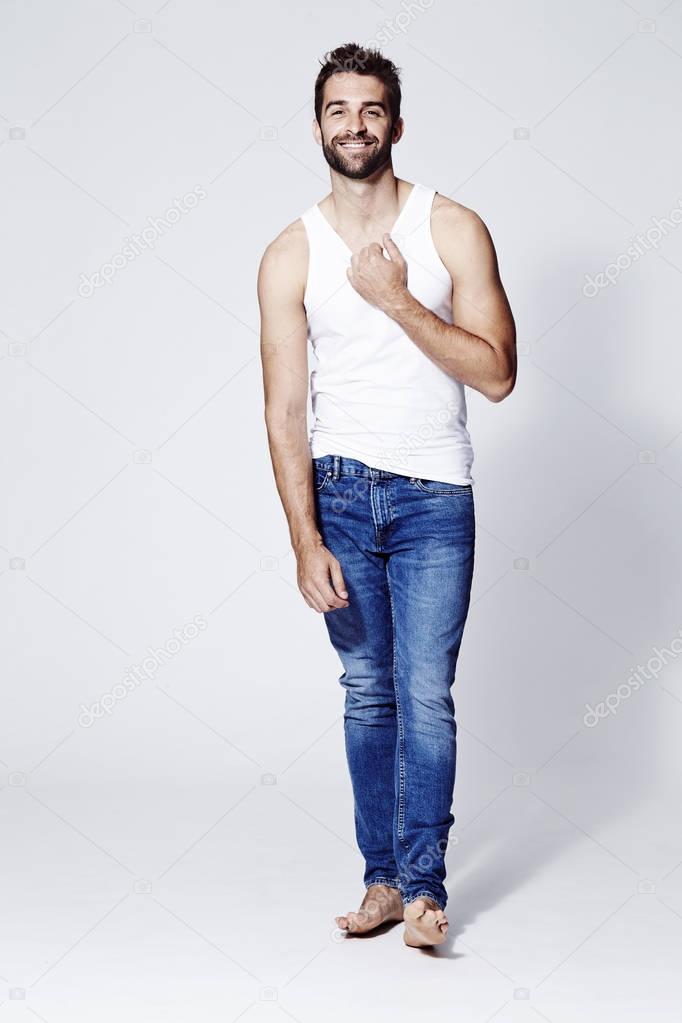 Barefoot man in vest and jeans