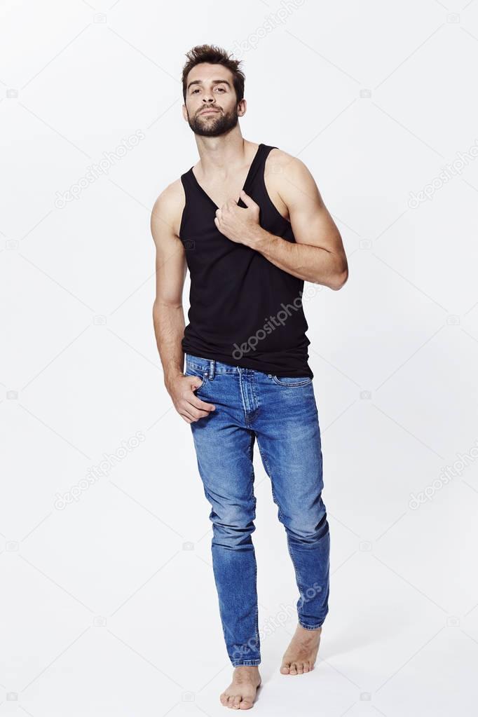 Guy posing in vest and jeans