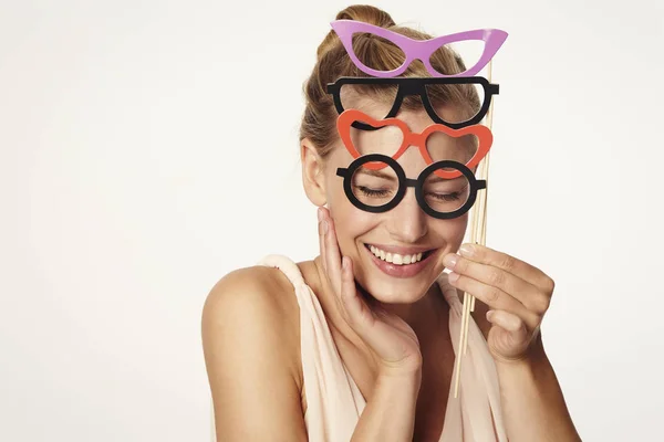 Mulher segurando pares de óculos — Fotografia de Stock
