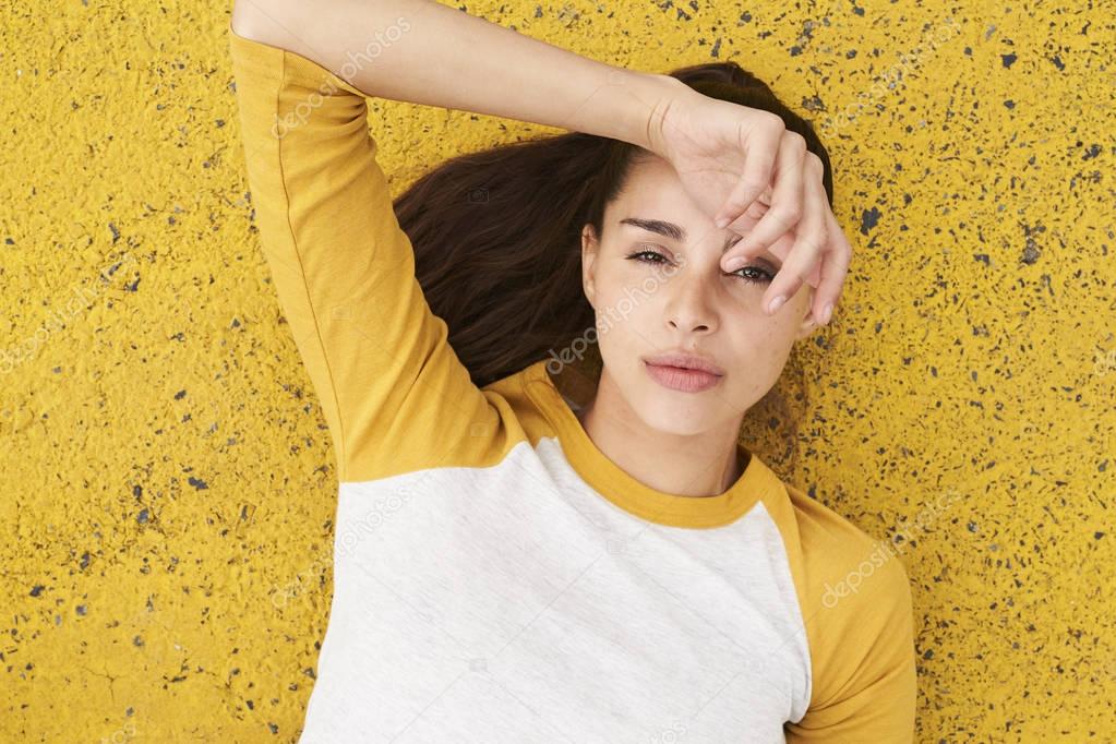 Young woman lying on yellow street