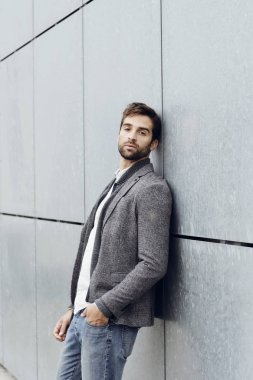 Gri duvara yaslanmış adam