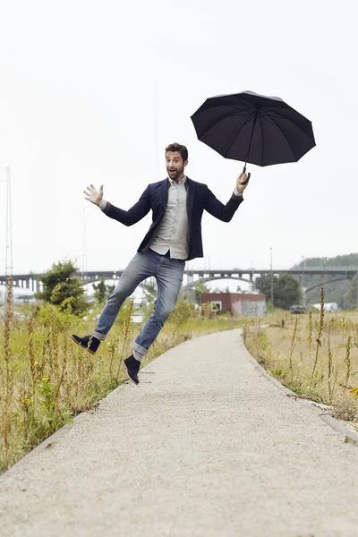 Ragazzo che salta con l'ombrello — Foto Stock