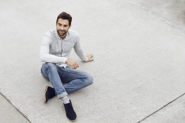 Kaldırımda oturan yakışıklı adam 