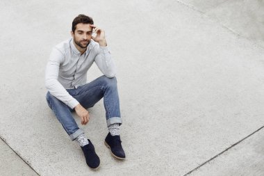 Kaldırımda oturan yakışıklı adam 