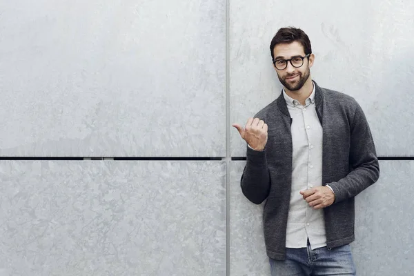 Guy wijzen op muur — Stockfoto