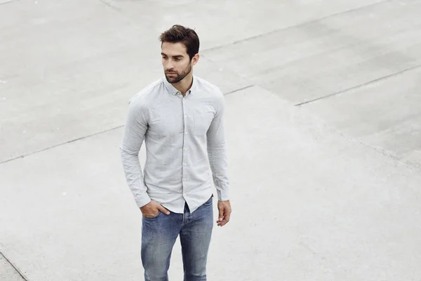 Красивый мужчина в рубашке и джинсах — стоковое фото