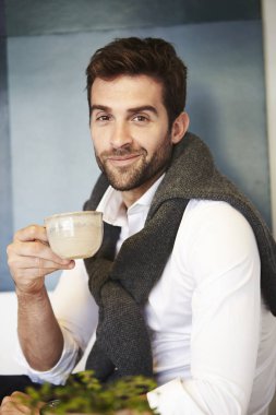 Kahve fincanı tutan adam.