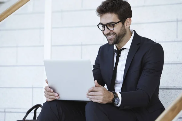 Businessman smiling at laptop — Stock Photo, Image