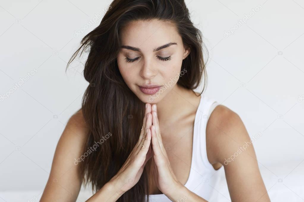Serene young woman praying