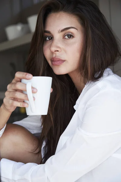 Vrouw in wit overhemd met koffie — Stockfoto