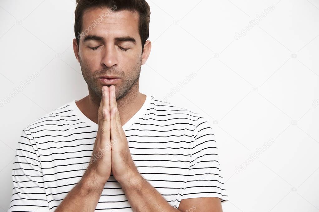 Man doing praying gesture 