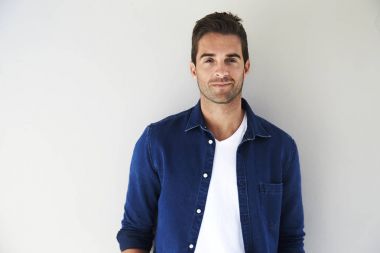 Yakışıklı genç adam ayakta beyaz duvar tarafından