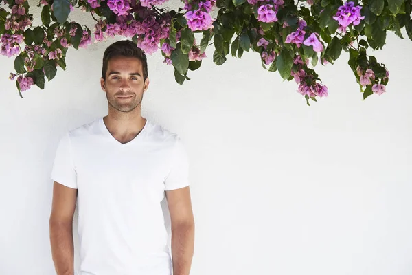 Man smiling under flowers — Stock Photo, Image