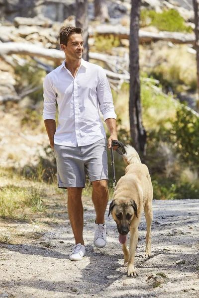 Homem bonito andando com cão — Fotografia de Stock