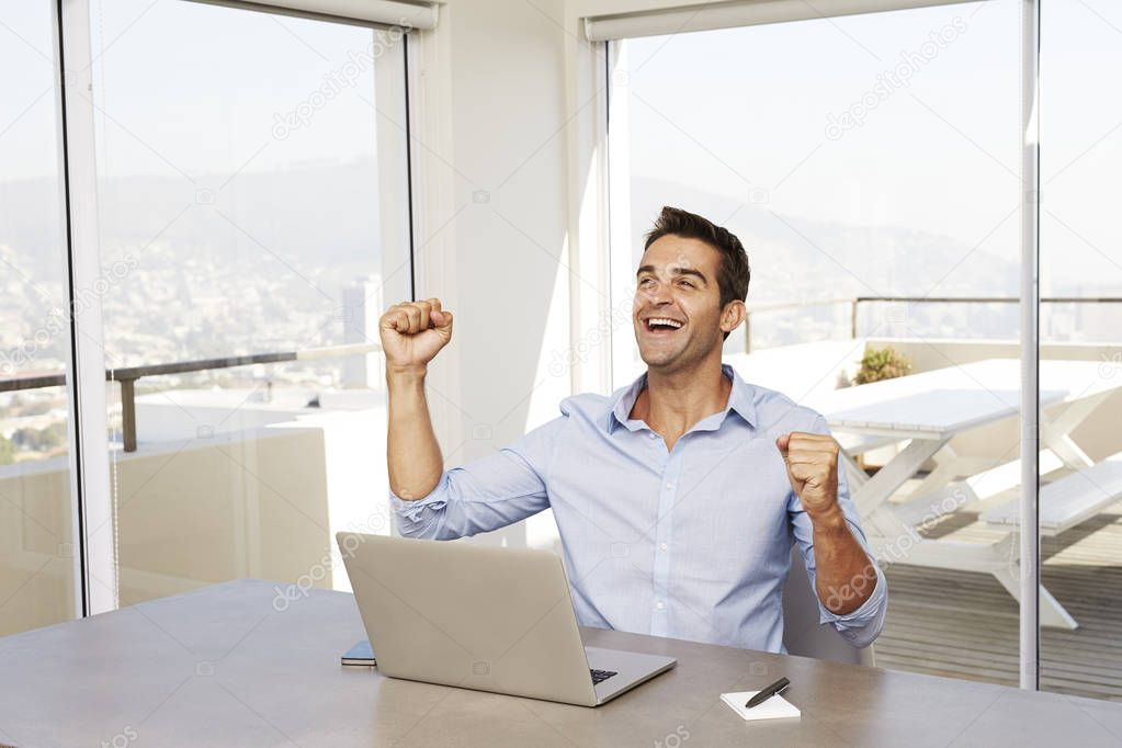 Happy young man using laptop 