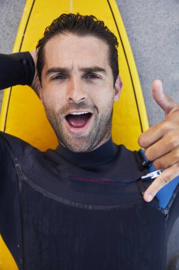 yakışıklı sörfçü gösteren shaka işareti