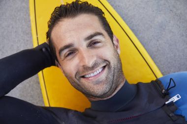 gemide yalan ve gülümseyen sörfçü