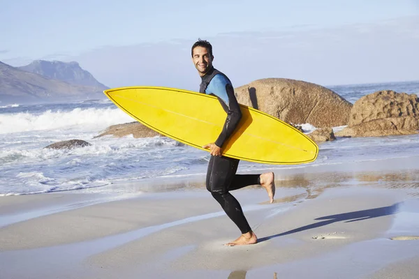 Surfer carrying board on beach — Stock Photo, Image