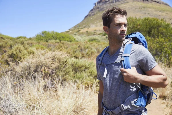 Handsome man hiking with backpack
