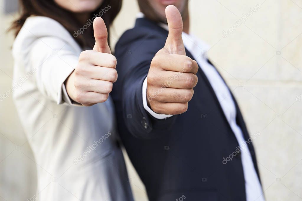 Business colleagues with thumbs up