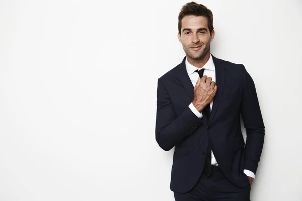 Handsome businessman adjusting tie — Stock Photo, Image