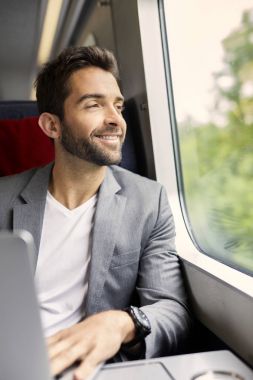 Yakışıklı olan dizüstü bilgisayar kullanarak trende