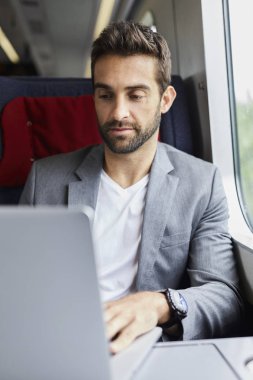Yakışıklı olan dizüstü bilgisayar kullanarak trende