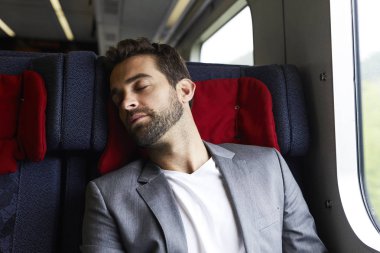 Trende uykuda takım elbiseli adam 