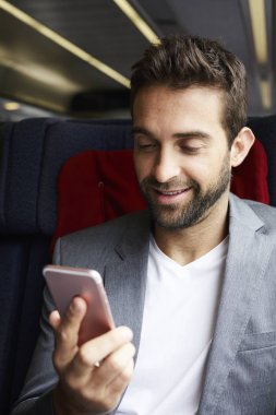 Cep telefonu kullanan yakışıklı genç adam. 