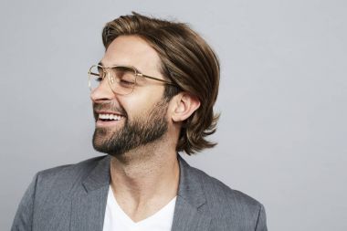gri takım elbise ceketi giyen sakallı adam