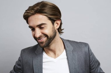 gri takım elbise ceketi giyen sakallı adam