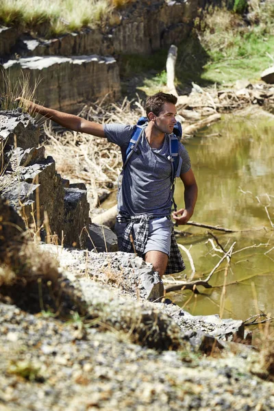 Kayalar tarafından ayakta yakışıklı uzun yürüyüşe çıkan kimse 