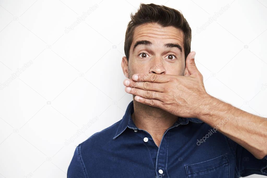 Surprised guy covering mouth with hand