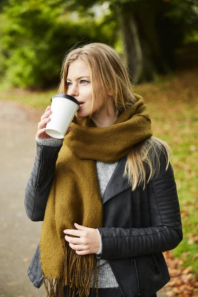 Woman with coffee in park — Stock Photo, Image