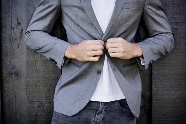 Guy in jeans buttoning suit jacket — Stock Photo, Image