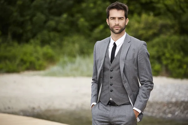Hombre de negocios fresco en traje gris — Foto de Stock