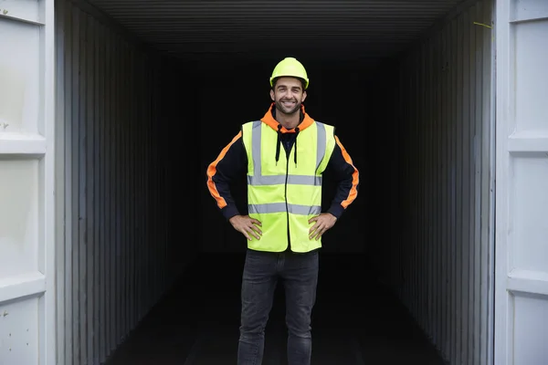 guy in hard hat standing by container