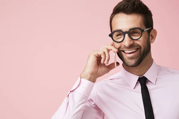 Uomo in camicia rosa che parla al telefono — Foto Stock